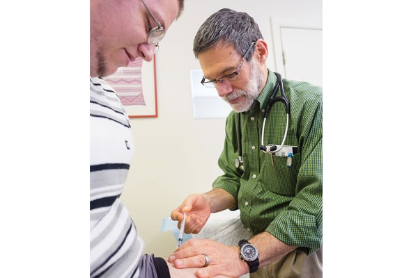 Dr. Martin Seltman gives Shane Collins a hormone shot at Metro Family Practice.