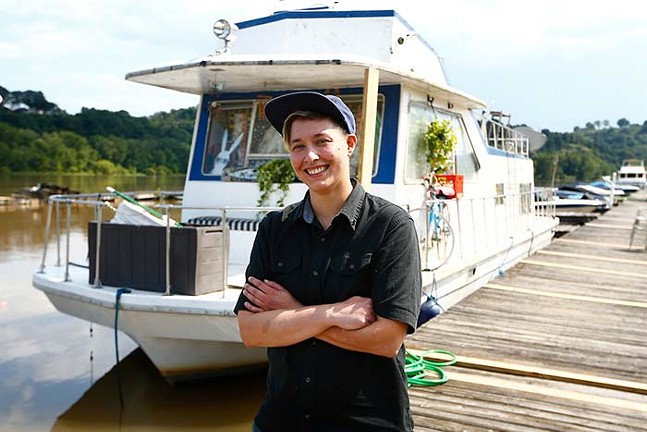 Mia Macdonald with her houseboat along the Allegheny River at the Bell Harbor Yacht Club