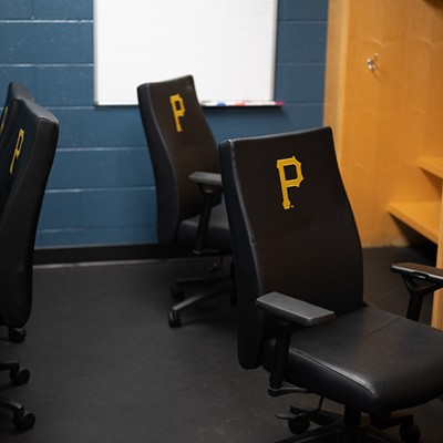 A locker room with Pirates-branded office chairs and spacious maple lockers.