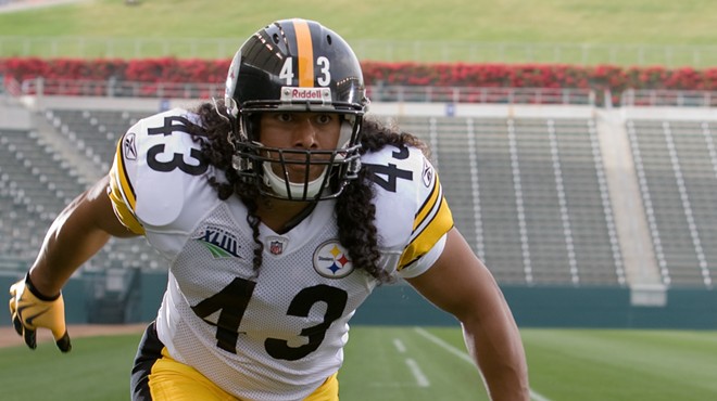 Troy Polamalu with his signature long hair in the Steelers' home white and gold uniforms