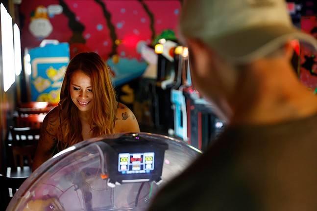 A woman and a man play games inside an arcade