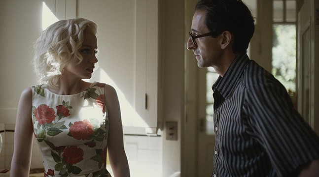 Actor Ana de Armas wears a floral dress as the late Marilyn Monroe, while Adrien Brody wears glasses and a collared shit as the playwright Arthus Miller, in the movie Blonde.
