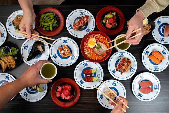 An overhead photo of colorful sushi dishes from Kura Revolving Sushi Bar