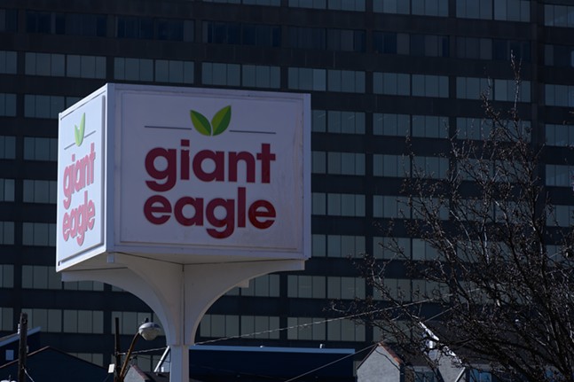 A Giant Eagle sign with high-rise windows in the background