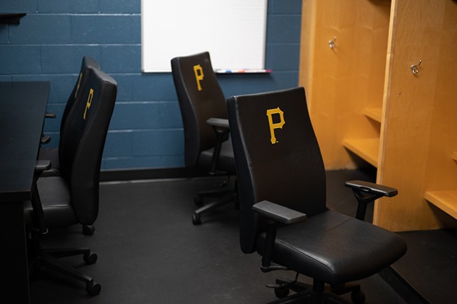 A locker room with Pirates-branded office chairs and spacious maple lockers.