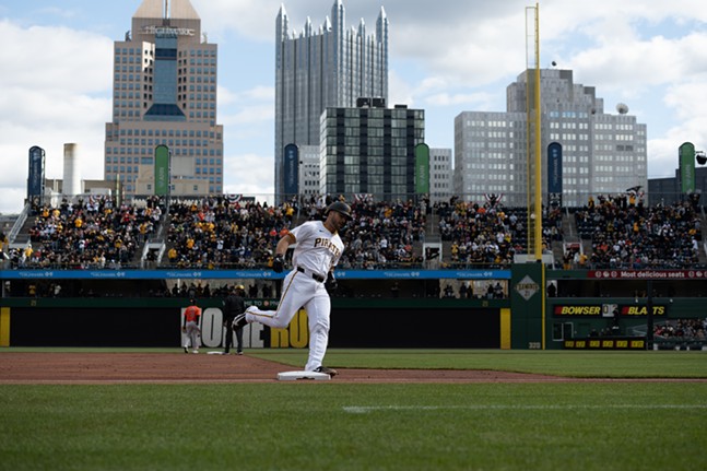 A PIrates player in white rounds third after a home run