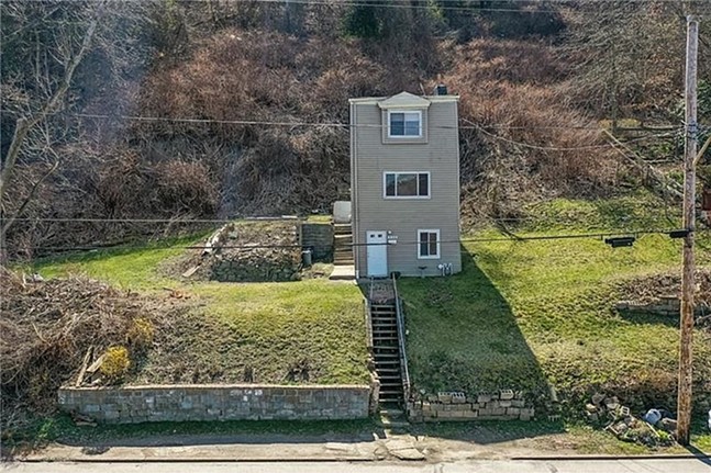 A skinny three-story house on a sloping lot