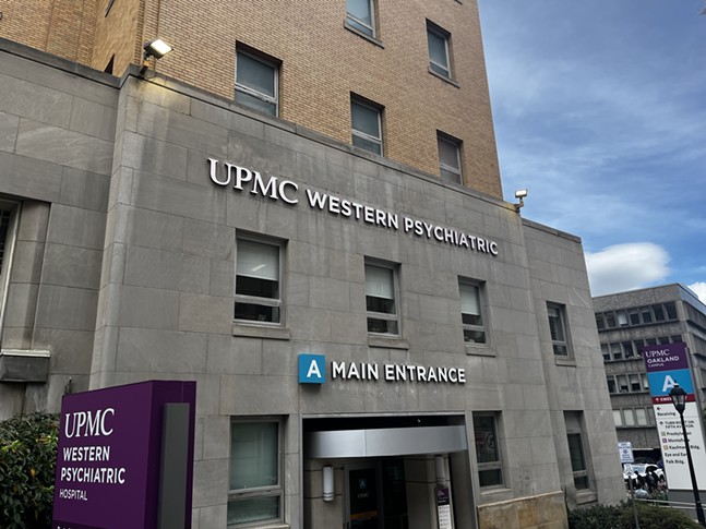 A stone façade on a yellow brick tower with signage for Western Psych's entrance