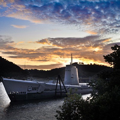 USS Requin (SS 481) with the sunset behind it.